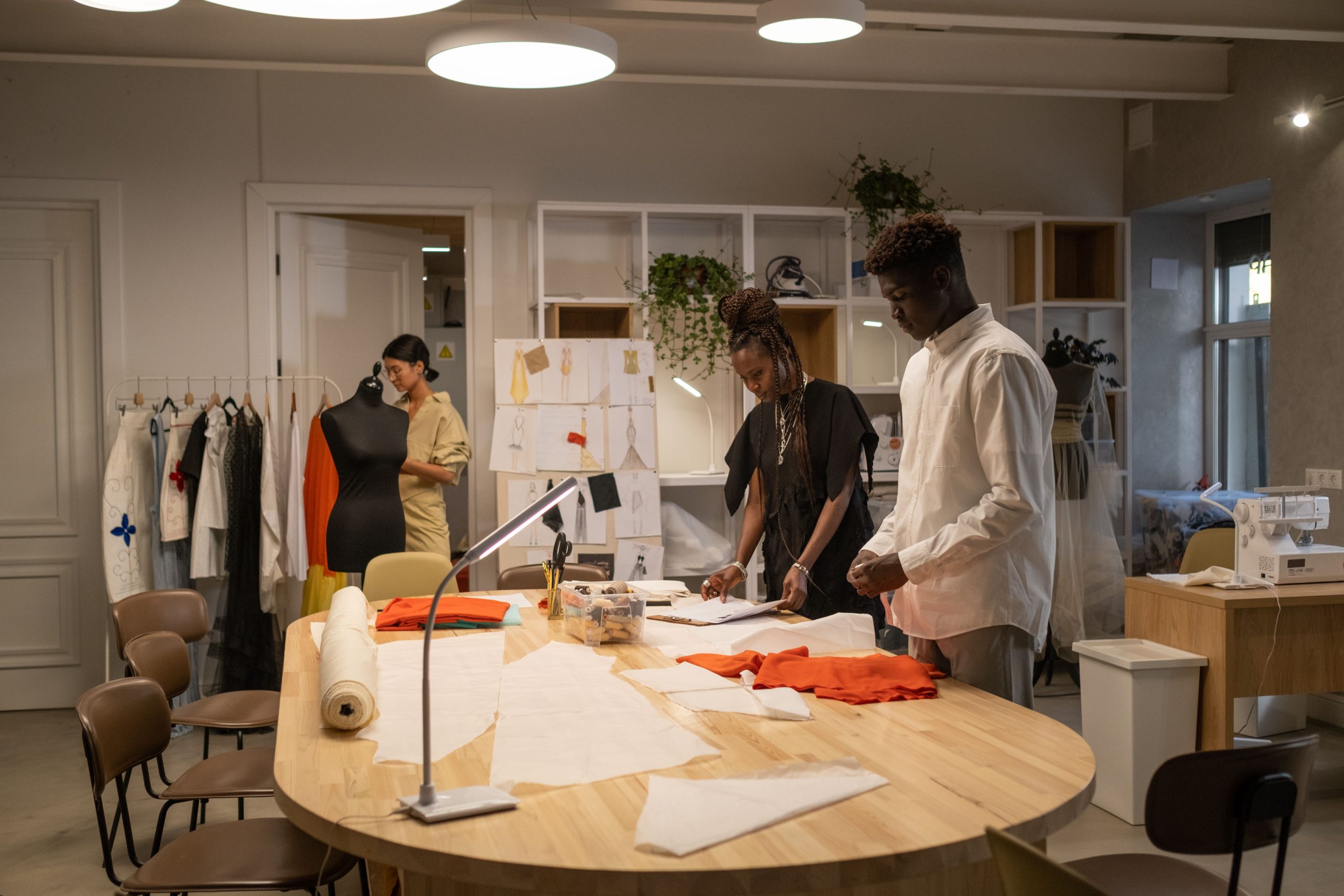 Fashion designers working in a stylish studio, creating garments and fashion ideas together.